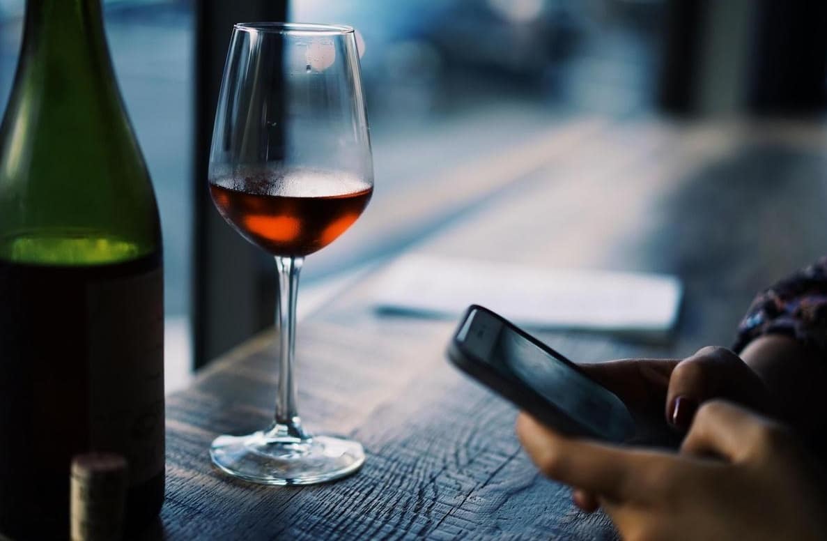 Homme avec son téléphone et un verre de vin