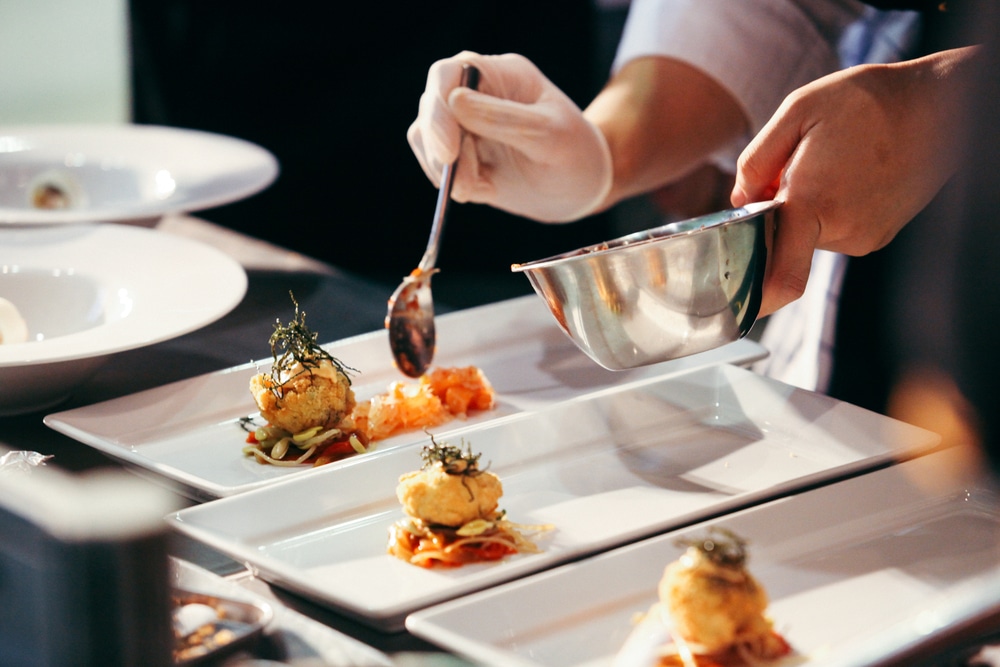 chef qui prépare un plat dans une cuisine professionnelle
